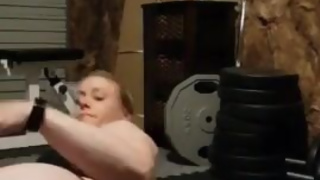 Muscular blonde striptease in home gym