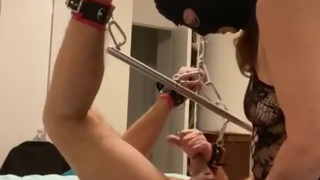 Femdom pegging sub locked in spreader bar chained to the ceiling